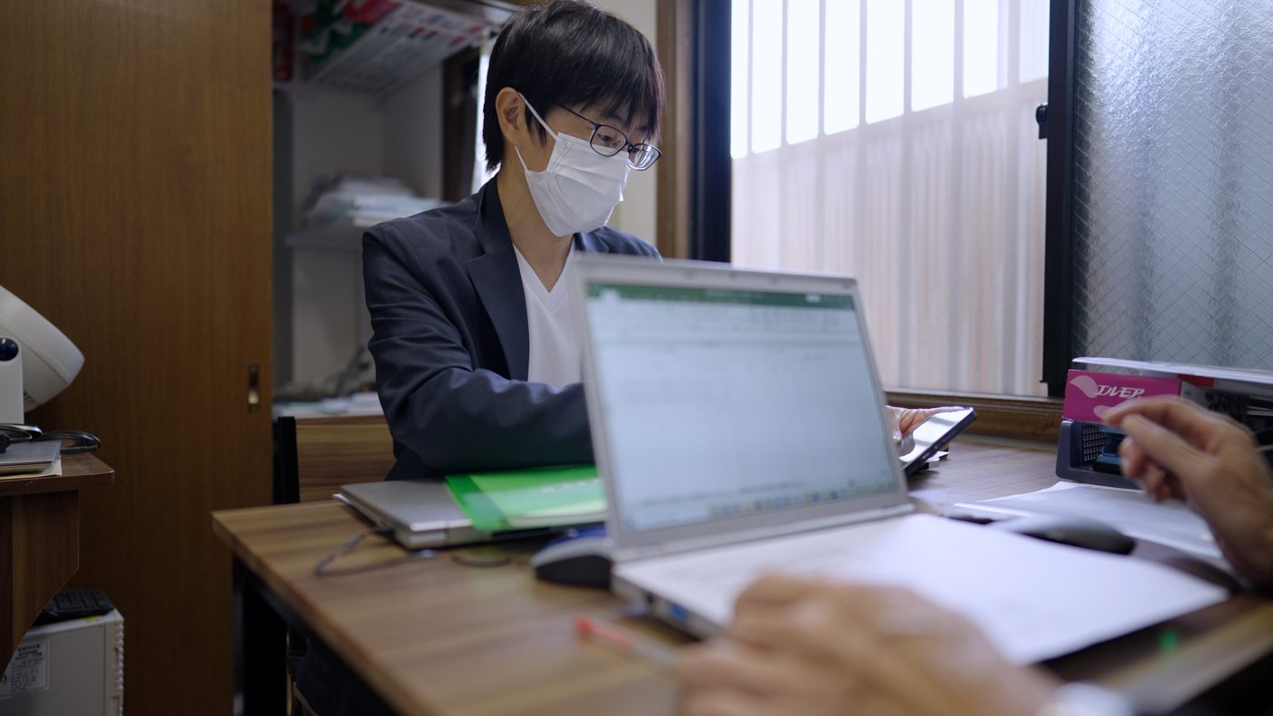 事務所で記録を確認するスタッフ